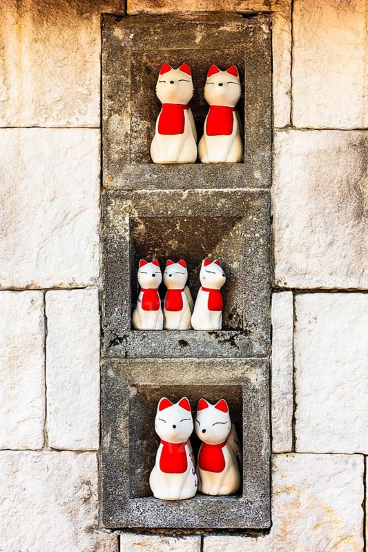 Maneki-neko Japanese-style cat figures in the Wat Phra That Don Phra Chan Buddhist temple, near Lampang, Lampang province, Thailand
