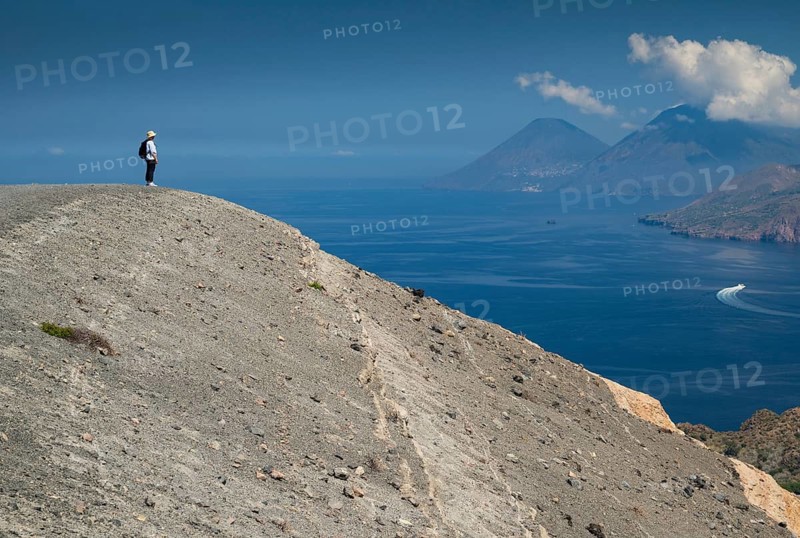 Visitor standing at the crater rim, Vulcano, in the background Lipari and Salina, Aeolian or Lipari Islands, Sicily, Southern Italy, Italy