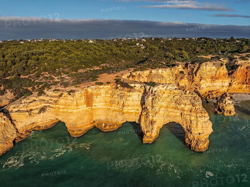 Aerial view of Praia da Marinha beach in Algarve, Portugal, with ocean cliffs, sea stacks and coastal cove shapes