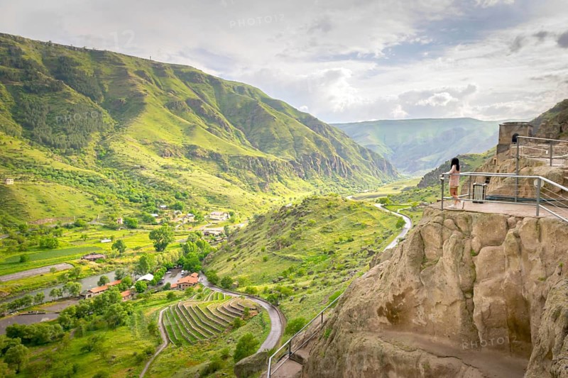 Female tourist enjoys stunning panoramic landscape view from Vardzia viewpoint. Georgia