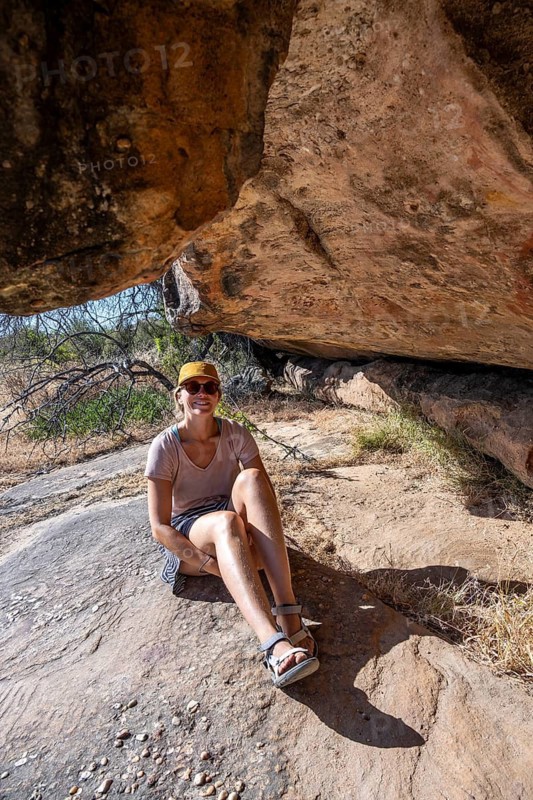 Tourist on a rock with prehistoric animal depictions, ancient rock carving of the San, indigenous people of South Africa, Seville Rock Art Trail, Cedar Mountains, Clanwilliam, Western Cape, Republic of South Africa