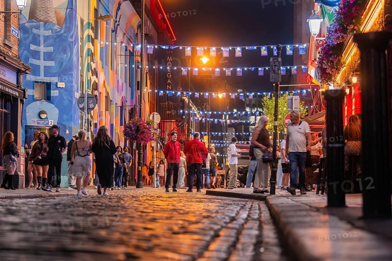 A busy street with people and festive lights in a lively atmosphere, nightlife, Dublin, Ireland
