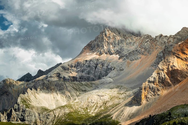 Dramatic mountain peaks colorful rocky scree slopes scenic alpine vista cloudy overcast sky mountain range background Malga Rossalm Dolomites South Tyrol Italy summer travel landscape