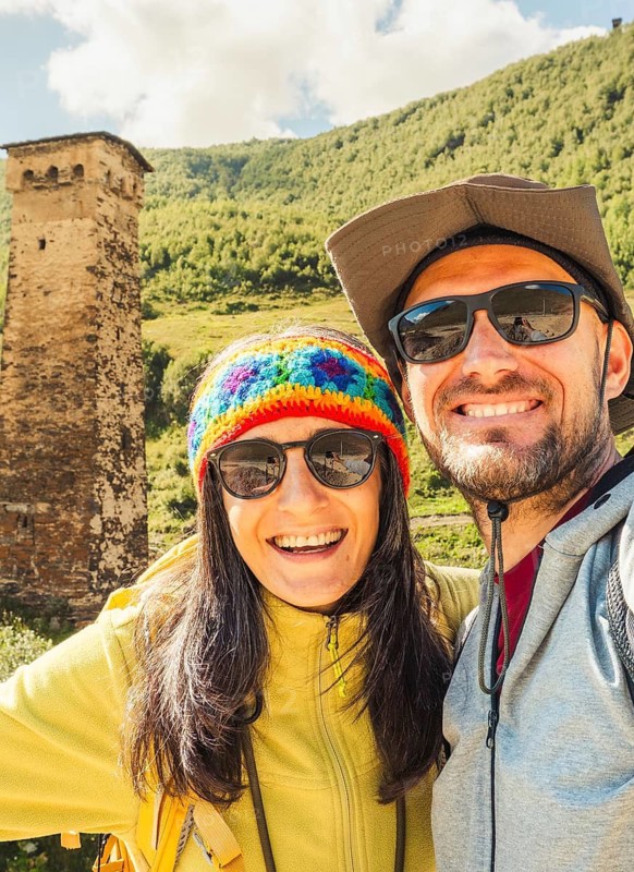 Smiling happy caucasian couple taking selfie by Ushguli svan tower settlement. Hiking in Svaneti Georgia. Man woman backpacking outdoors near historical Unesco world heritage site
