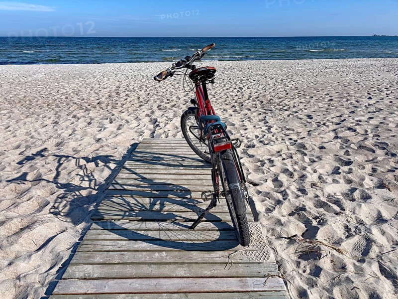 Bicycle standing on a wooden path on a sunny beach with a view of the sea and the blue sky, bicycle tourism, Löttorp, Öland, Sweden