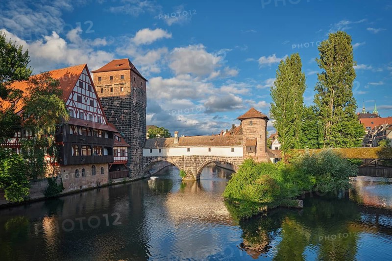 Golden sunset light illuminating the Henkersteg bridge and historical buildings on the Pegnitz river in Nuremberg, Bavaria, Germany