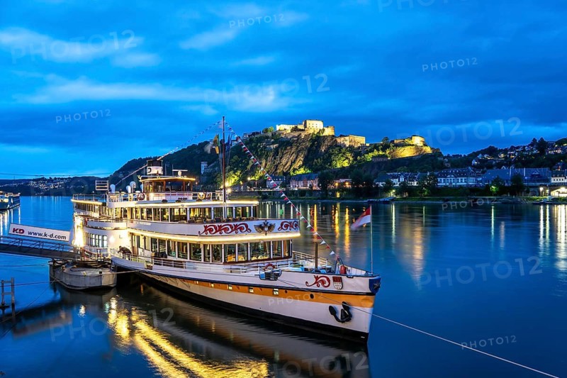 The Ehrenbreitstein Fortress, on the right side of the Rhine, opposite the Deutsches Eck, evening lighting, sightseeing boat on the left bank, Koblenz, Rhineland-Palatinate, Germany