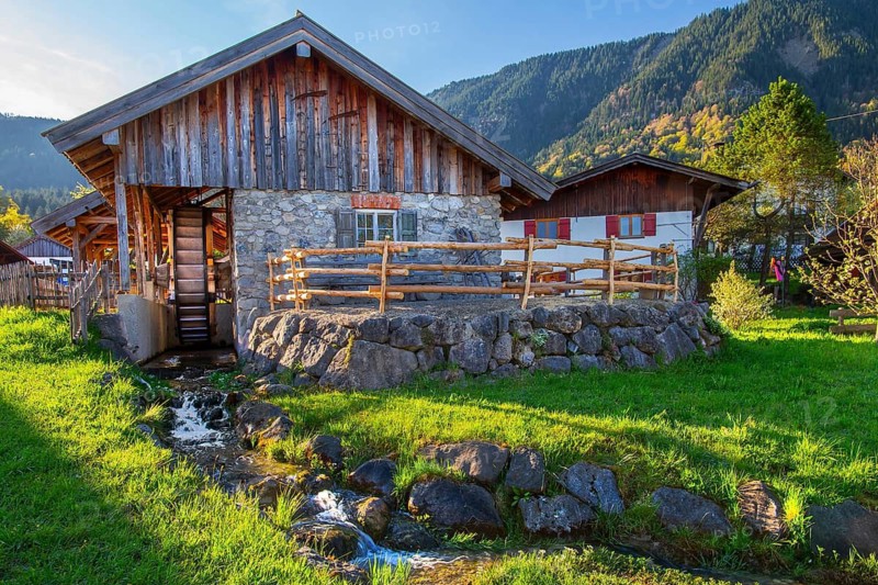 Historic Schleifmühle, water mill, in the village in spring, Ohlstadt, Loisach Valley, The Blue Land, Upper Bavaria, Bavaria, Germany