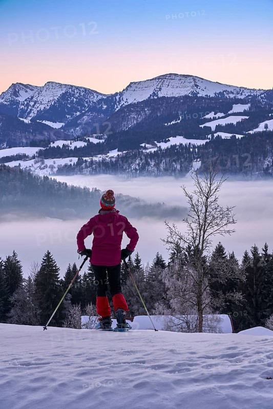 Sportive woman watching sunrise over the Nagelfluh mountain chain with Hochgrat summit in the Allgaeu Alps, Oberstaufen, Bavaria, Germany