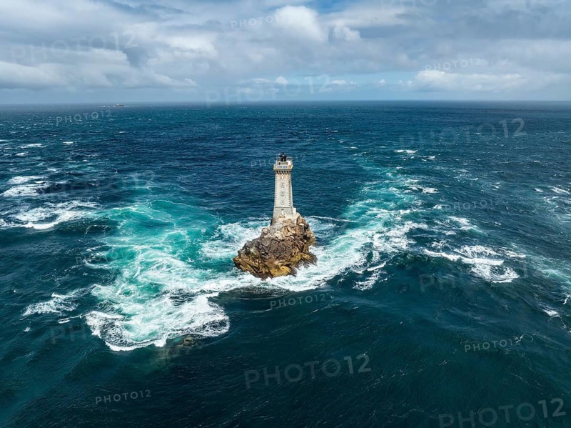 Aerial view of the historic Phare de la Vieille lighthouse, built from 1882 to 1887 on a rocky reef in the midst of stormy, foaming ocean waves, Raz de Sein strait, Pointe du Raz, Plogoff, Quimper Arrondissement, Finistère, Région Bretagne, France