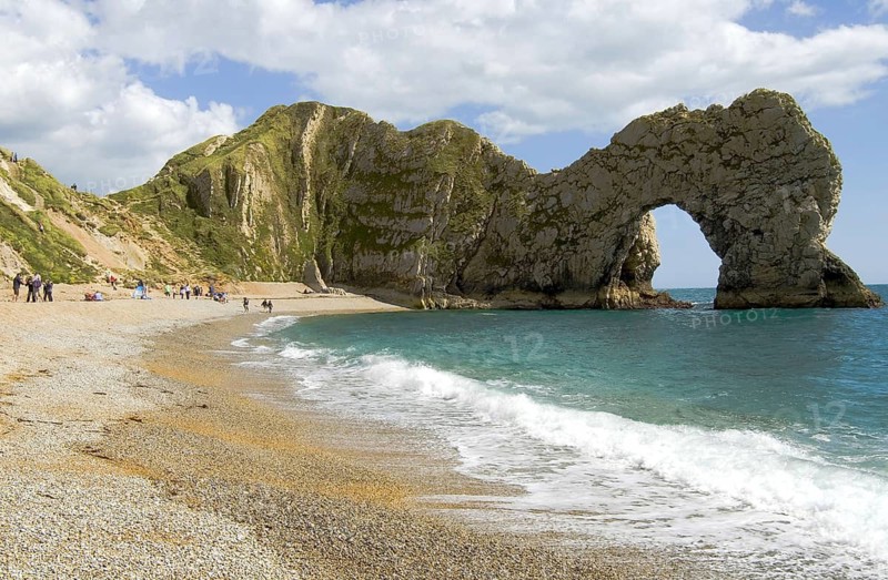 The beach at Durdle Door, a natural limestone rock arch on the Jurassic Coast that attracts numerous tourists