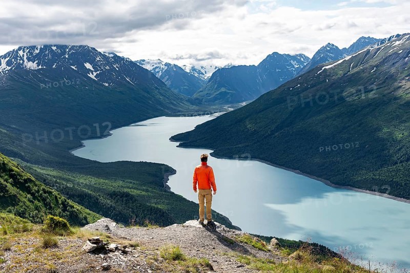 Mountaineer enjoys views of blue lake and mountains on Twin Peaks Trail, Eklutna Lake, Chugach Mountains, Chugach State Park, Alaska, USA