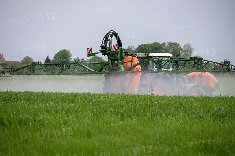 Farmer fighting weeds in his meadow, Beerbach, Middle Franconia, Bavaria, Germany