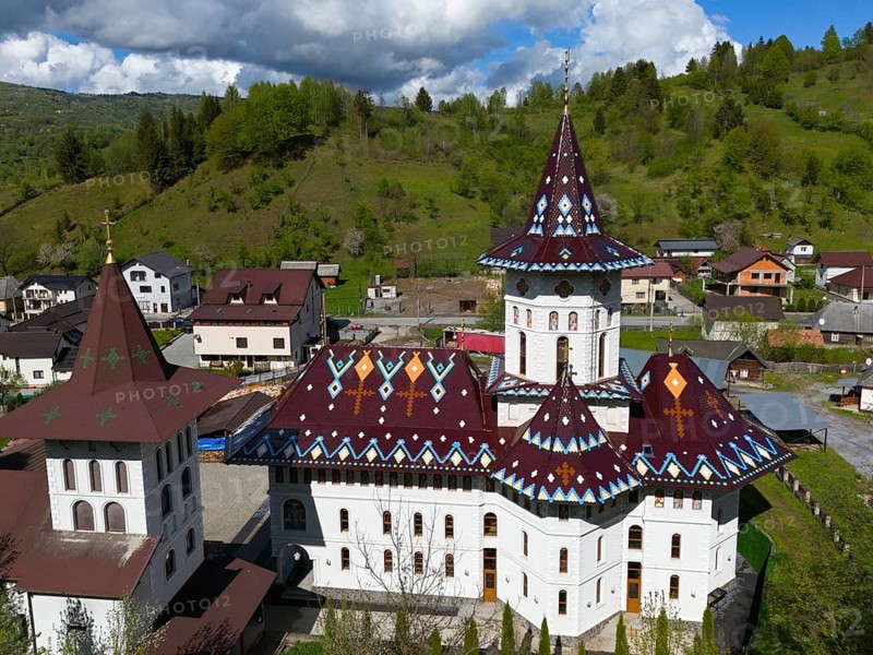 Combination of Orthodox church and surrounding village in hilly landscape under cloudy sky, aerial view, Biserica Acoperamântul Maici Domnului, Moisei, Maramure?, Maramures, Maramures region, Romania