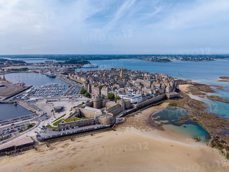 Aerial view of the famous corsair town of Saint Malo, France, with its distinctive granite buildings, city fortifications and wide sandy beach at low tide, Côte d'Émeraude, Emerald Coast, Ille-et-Vilaine department, Brittany, English Channel, France