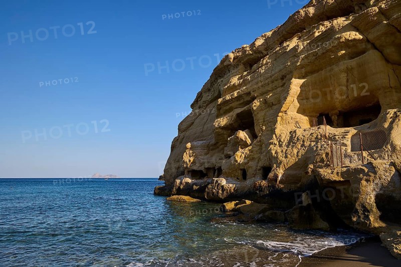 Neolithic caves, former hippie paradise, rocky cliffs by the sea, sunny day with blue sky and calm lake, Matala, south coast, Crete, Greek Islands, Greece