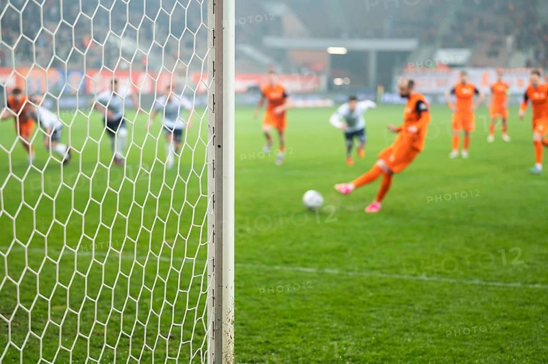 Detail of goal's post with net and football player during penalty kick in the background in Lubin, Poland