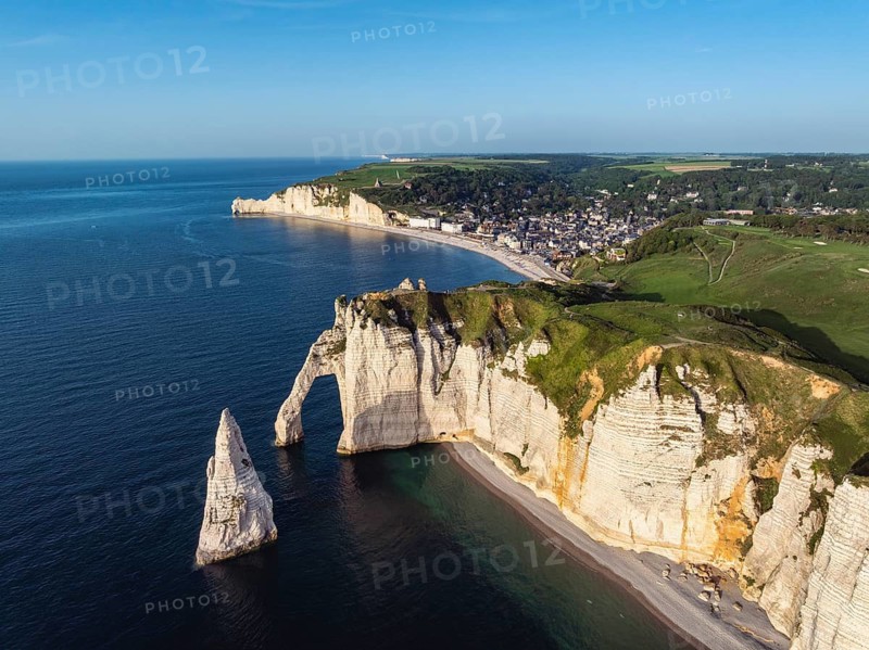 Aerial view of the Porte d'Aval rock formation in the evening sun, well-known sights on the chalk coast with the distinctive rock needle, behind it the holiday resort of Étretat with the beach, on the horizon the Falaise d'Amont cliffs, right on the cliffs the Golf d'Étretat golf course founded in 1908, Alabaster Coast, La Côte d'Albâtre, chalk cliffs, English Channel, Seine-Maritime, Normandy, France