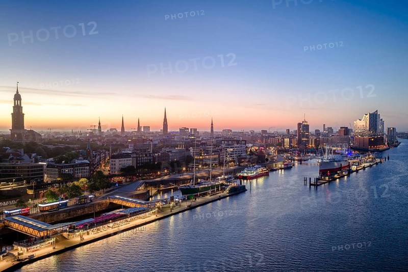 Aerial view of Landungsbrücken (Jan Fedder Promenade) at sunrise on the Elbe with Elbe Philharmonic Hall, St Michael's Church (Michel) and Cap San Diego, Hamburg, Germany