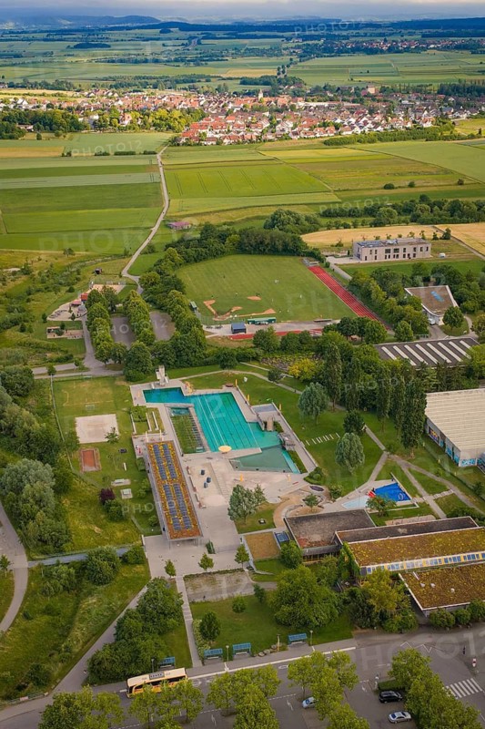 Sports complex with large swimming pools surrounded by greenery and fields under a cloudy sky, Herrenberg, Böblingen district, Germany