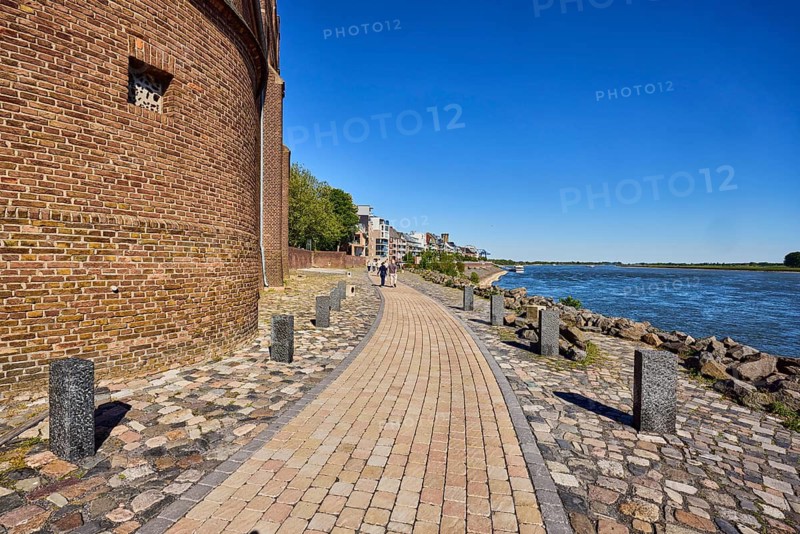 Rhine river, general architecture, brick building, waterfront, footpath, trees, walkers as a secondary motif, blue sky, cloudless, Rhine promenade, Emmerich am Rhein, Kleve district, North Rhine-Westphalia, Germany