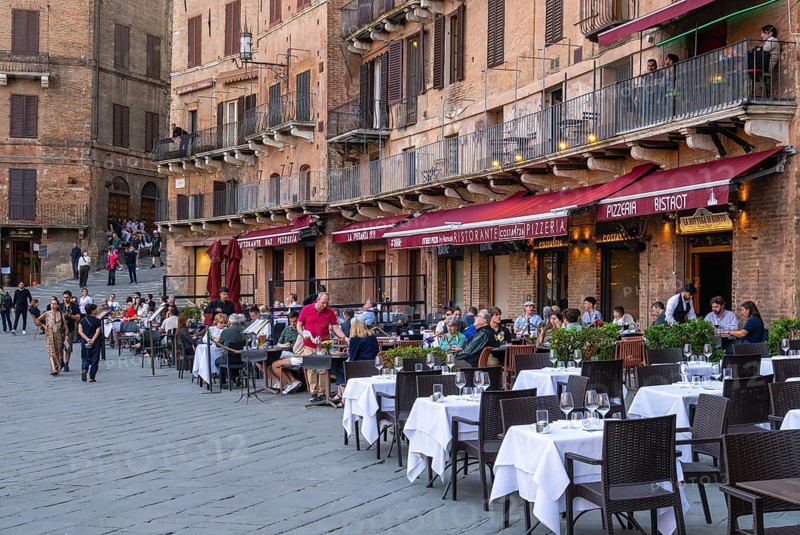 Tourists, sights and restaurants on the famous Piazza del Campo, Siena, Tuscany, Italy