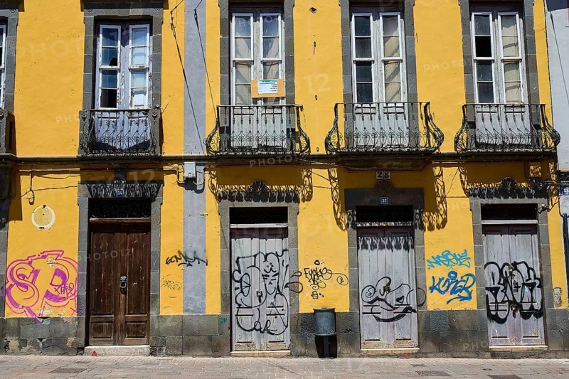Yellow building with graffiti on doors and balconies in an urban environment, capital, Santa Cruz de Tenerife, Santa Cruz, Tenerife, Canary Islands, Spain