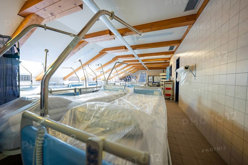 A warehouse with rows of hospital beds under a wooden ceiling, old disused hospital, Calw, Germany