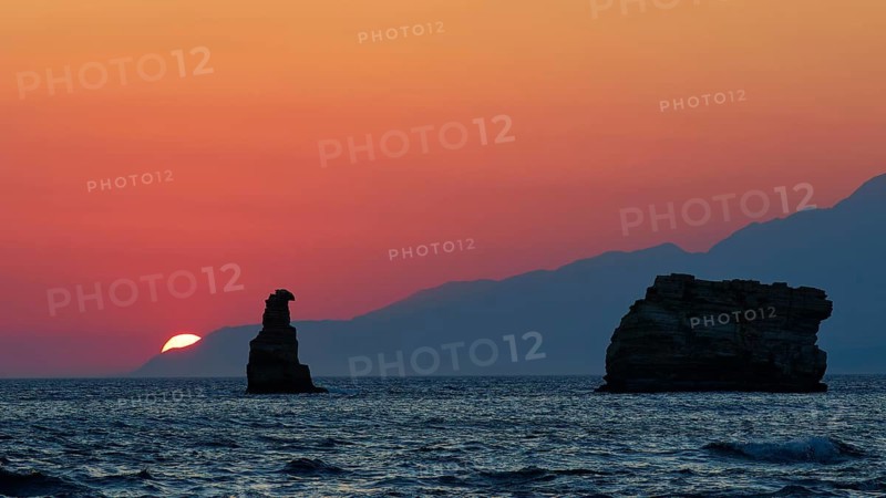 Calming sunset over the sea with a rock and mountains on the horizon, sunset, South of the Amari Basin, Central Crete, Triopetra, rocks in the sea, Crete, Greek Islands, Greece