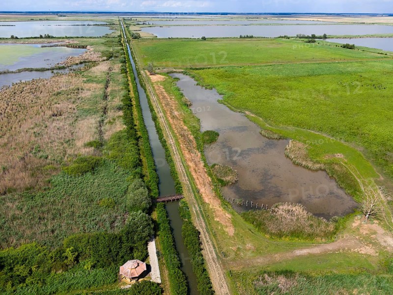 Aerial view of a canal stretching through vast fields and nature, aerial view, Hortobagyer fish ponds, Hortobágyi halastó, Hortobagy, Hortobagy National Park, Hortobágyi Nemzeti Park, Hortobágyi Csillagoségbolt Park, Puszta, steppe area, UNESCO Biosphere Reserve, Hungary