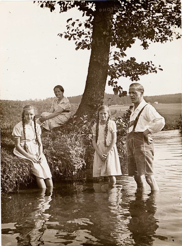 Bathing, swimwear, leisure, summer, woman, man, girl, family standing in water near a tree on a rural stream bank, around 1928