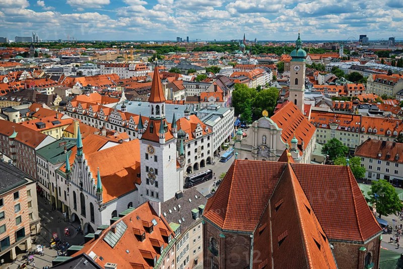 Elevated shot of the Altes Rathaus tower and the historic Marienplatz area with buses and traffic in Munich, Bavaria, Germany in summer