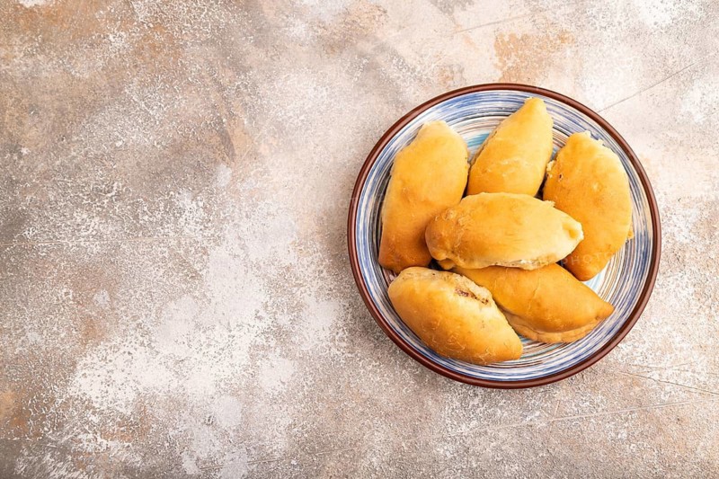 Homemade pies with jam and curd on brown concrete background, copy space, top view, flat lay