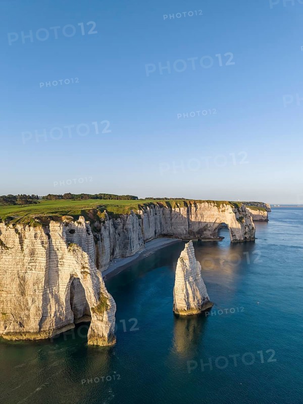 Aerial view of the Porte d'Aval rock formation in the evening sun, well-known sights on the chalk coast with the distinctive Aiguille d'Étretat rock formation, behind it the La Manneporte rock gate and the Pointe de la Courtine ledge, then Pointe du Fourquet, right on the cliffs of the Golf d'Ètretat golf course founded in 1908, Alabaster Coast, La Côte d'Albâtre, chalk cliffs, English Channel, Seine-Maritime, Normandy, France