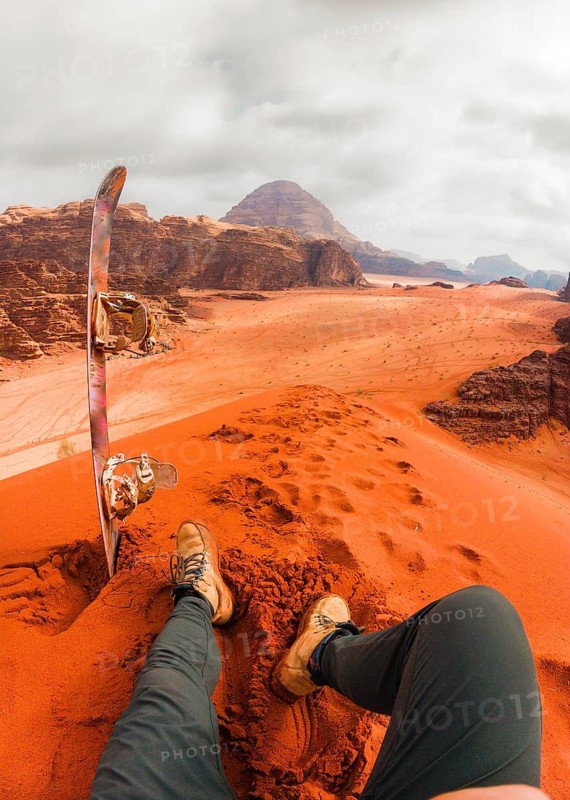 Rider pov Sand boarding from red dune Wadi Rum Jordan, traveler POV with board, desert adventure freedom concept. Wadi rum tours and Sand boarding, hiking, wandering outdoors activities