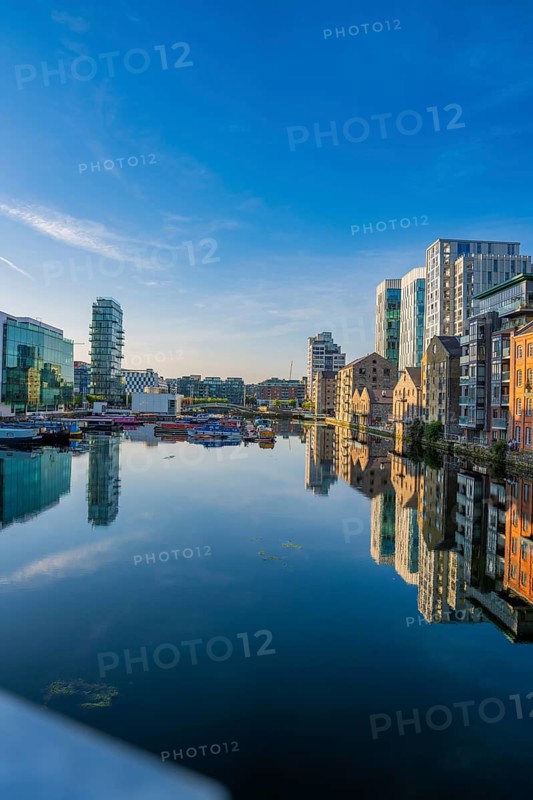 Calm morning on the canal with building mirrors under a clear sky in the city, Dublin, Ireland