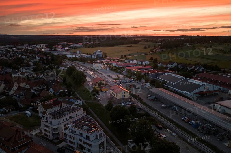 Panorama of a city at sunset with vast fields and buildings, bright orange sky, Hermann Hesse Railway, Althengstett, Calw district, Germany