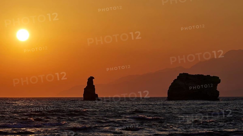 A warm sunset over the sea, rocks silhouetted against the orange sky, sunset, south of the Amari Basin, Central Crete, Triopetra, rocks in the sea, Crete, Greek Islands, Greece