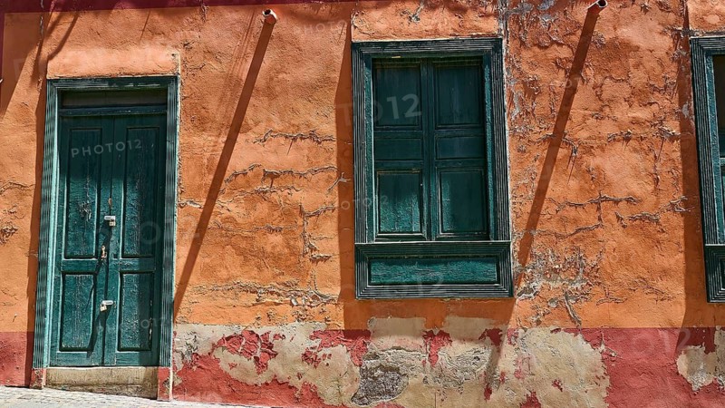 Weathered orange house wall with green windows and an old door, capital city, Santa Cruz de Tenerife, Tenerife, Canary Islands, Spain