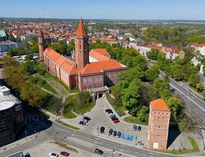 Castle in urban surroundings, with distinctive orange roofs and surrounding roads, aerial view, Piast Castle, front right The Glogauer Gate Tower, Legnica, Liegnitz, Lower Silesia Voivodeship, Poland
