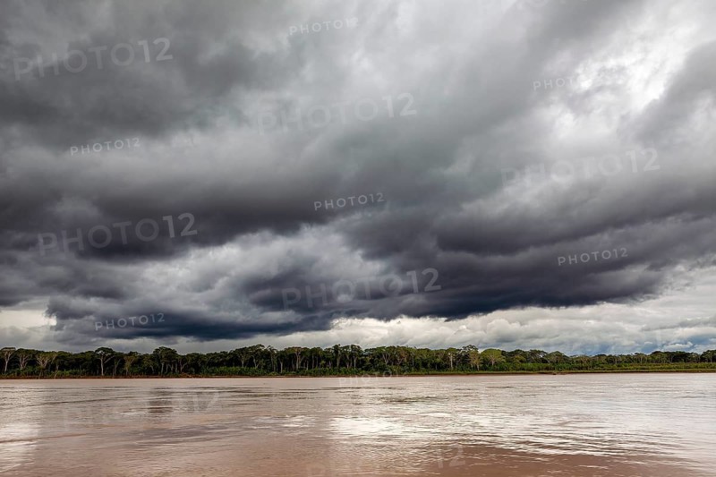 Threatening clouds over a river and wooded bank, The Beni River near Rurrenabaque in the Amazon Basin in Bolivia