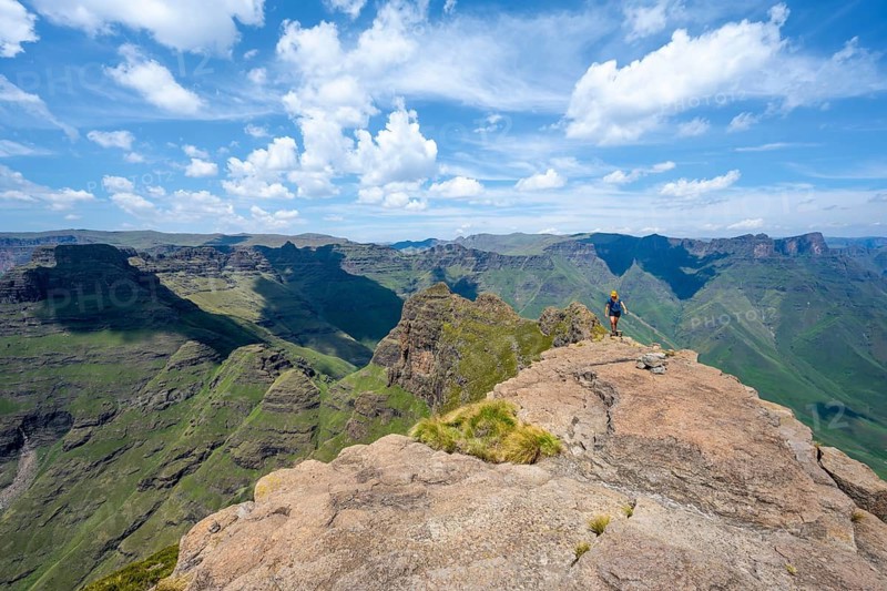 Female hiker in the mountains of the Cathedral Range, view from the summit of Cathedral Peak or Cathedralpiek or Mponjwana, Drakensberg Mountains, KwaZulu-Natal, South Africa