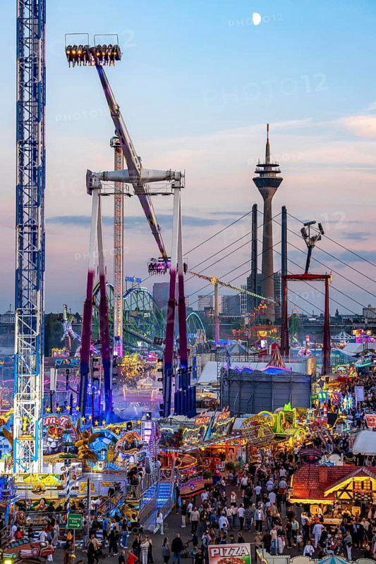 Rhine fair in the Rheinwiesen in Düsseldorf-Oberkassel, view towards the Rhine Tower, Rheinkniebrücke, rides, fairground stands, full corridors, lots of visitors, North Rhine-Westphalia, Germany