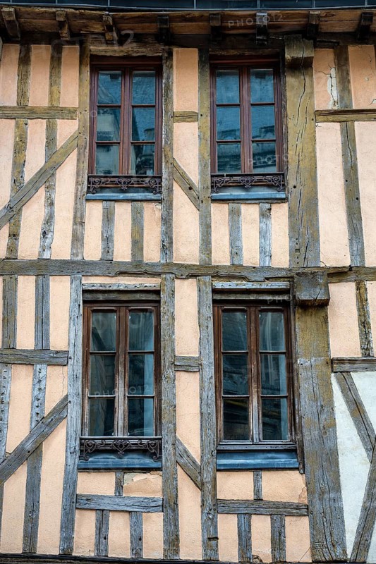 Historic half-timbered façade with distinctive wooden beams and four latticed windows on a traditional building in the old town of Troyes, Aube department, Grand Est region, France