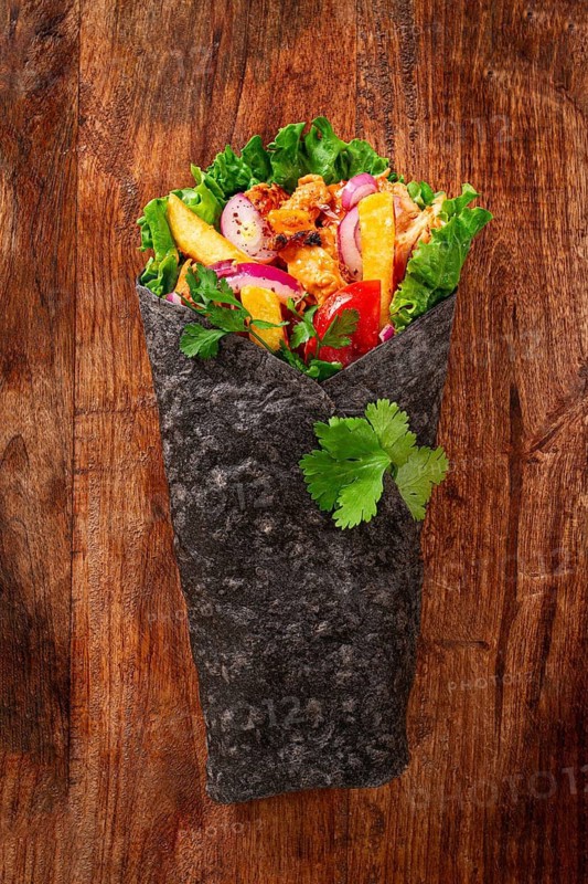 Shawarma in black lavash, on a wooden background, chicken shawarma, no people