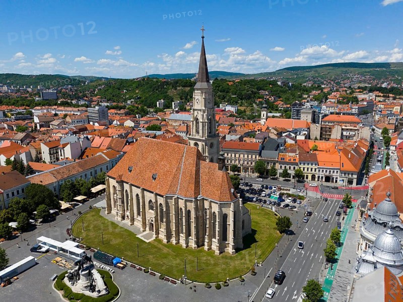 Large historic church in the city center with surrounding buildings and mountains in the background, aerial view, St. Michael's Church in Cluj, Gothic hall church, statue of Matthias Corvinus, Cluj-Napoca, Cluj, Transylvania, Transylvania region, Romania
