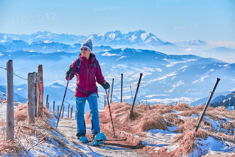 Woman hiking with snowshoes in snowy mountains, Bregenz Forest, Vorarlberg, Austria