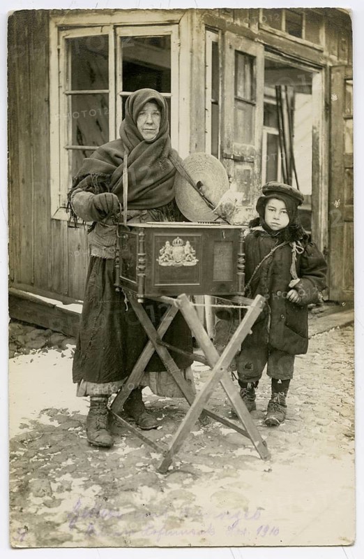 Jews, woman with an organ, child, Vilnius, Lithuania, poverty, World War I, elderly woman and child standing with a barrel organ on a snow-covered street
