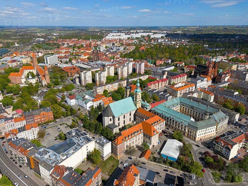 Aerial view of a city with various churches and buildings surrounded by green spaces under a blue sky, aerial view, St. John's Church in front and Knight's Academy to the right, Legnica, Liegnitz, Lower Silesia Voivodeship, Poland