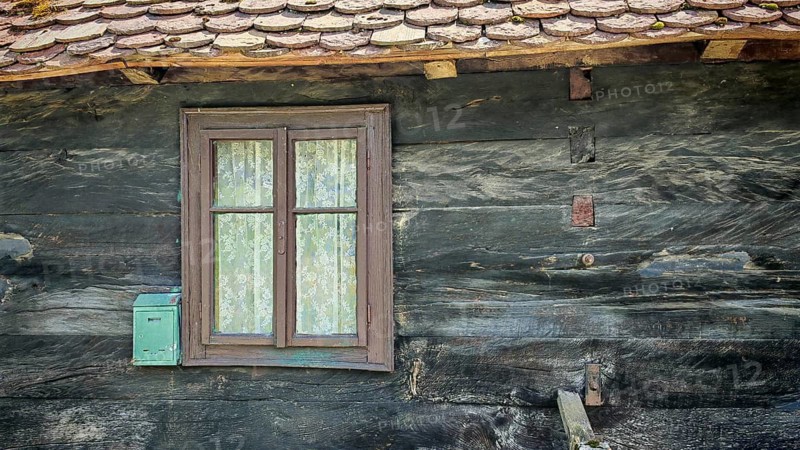 Old traditional wooden house with simple windows, wooden shingles and rustic appearance, classic rural architecture, Croatia